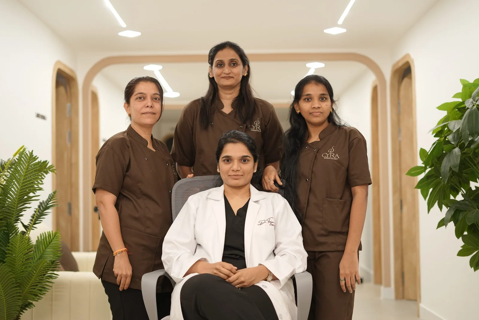 Dr. Tejaswi Kothapally seated with three members of the Cyra team in the clinic corridor